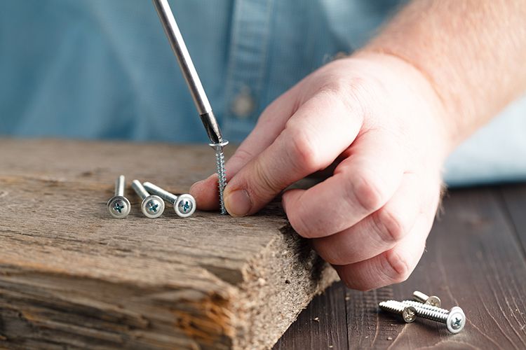 Screw being screwed into a piece of wood
