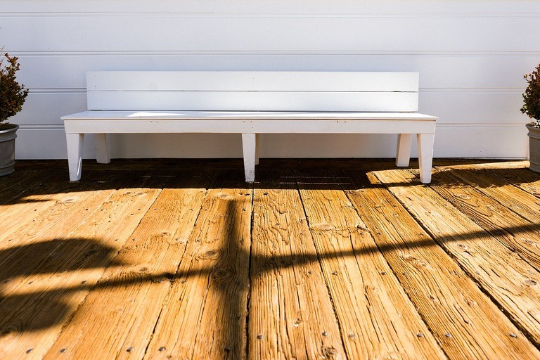 white bench placed on a wooden deck