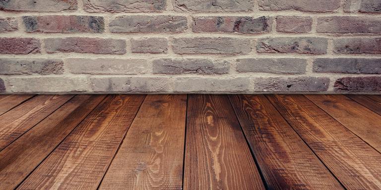 view of a brick wall on top of wooden floor