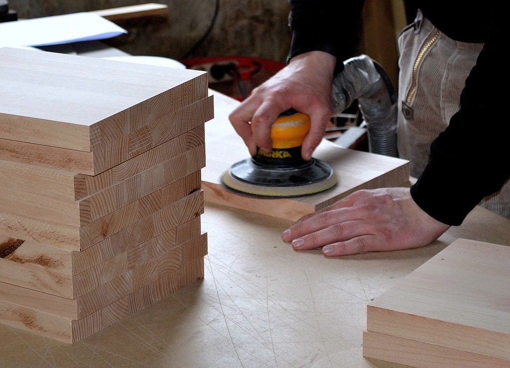 man using a planer on wood